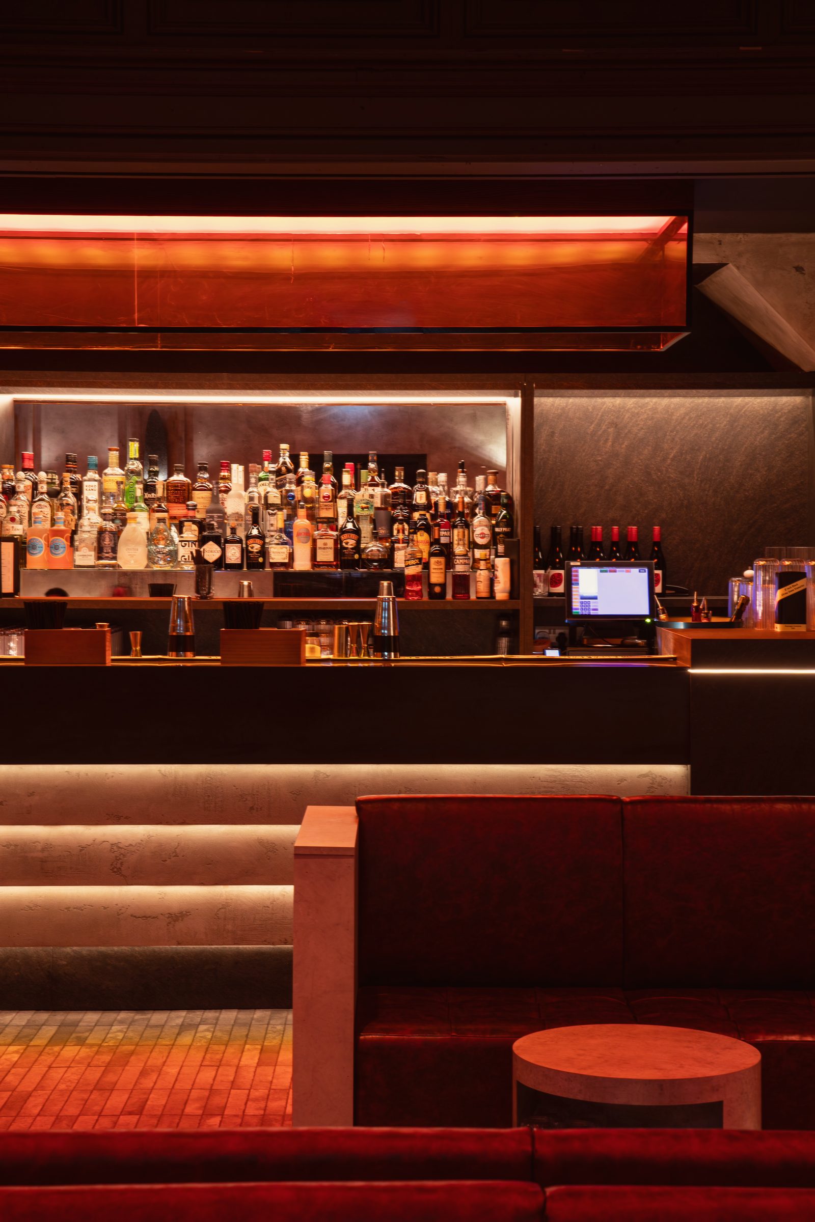 The Club Room bar: lit shelves of bottles beneath an amber light box