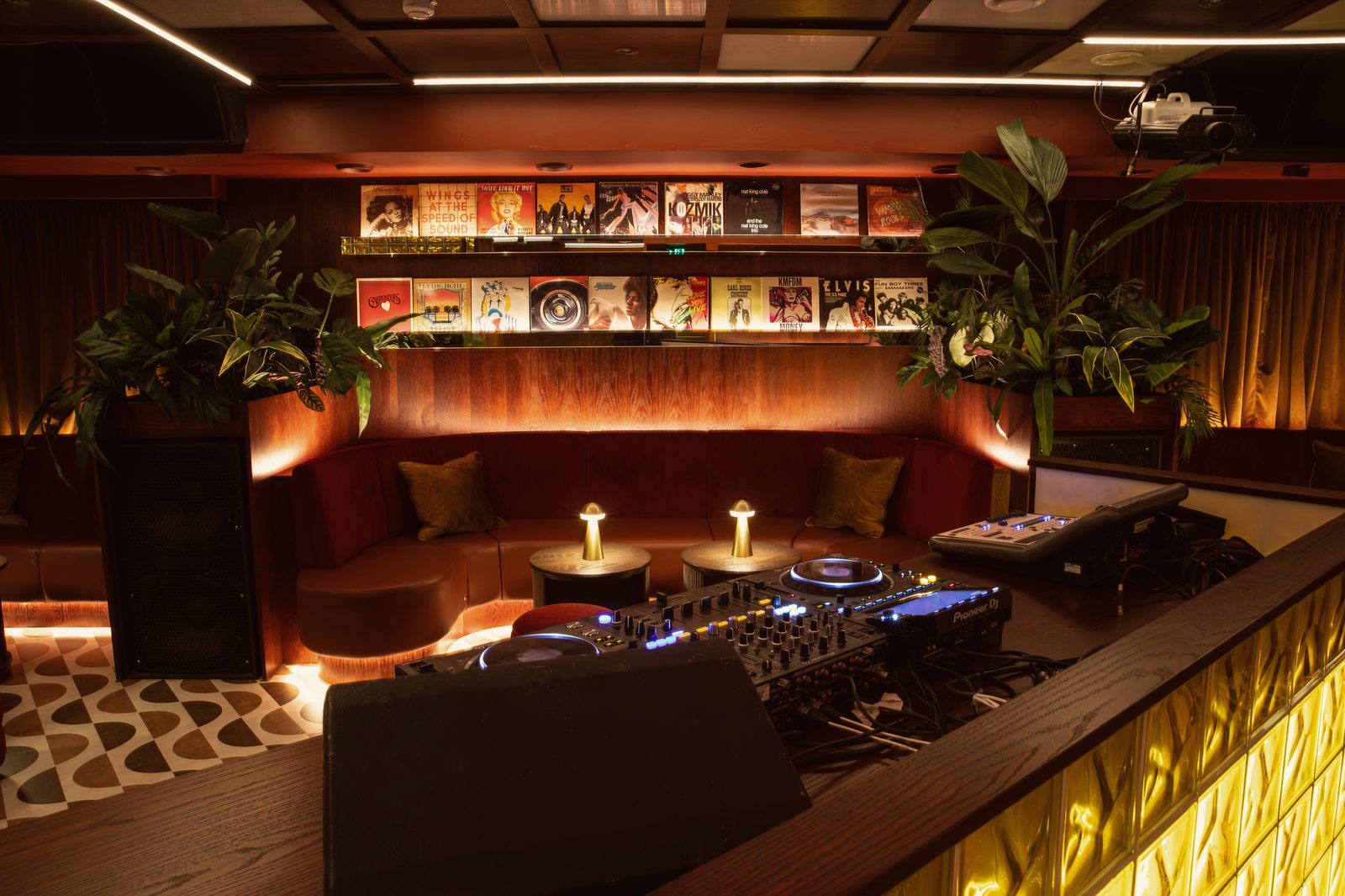 Over the decks to a curved velvet banquette beneath the record wall