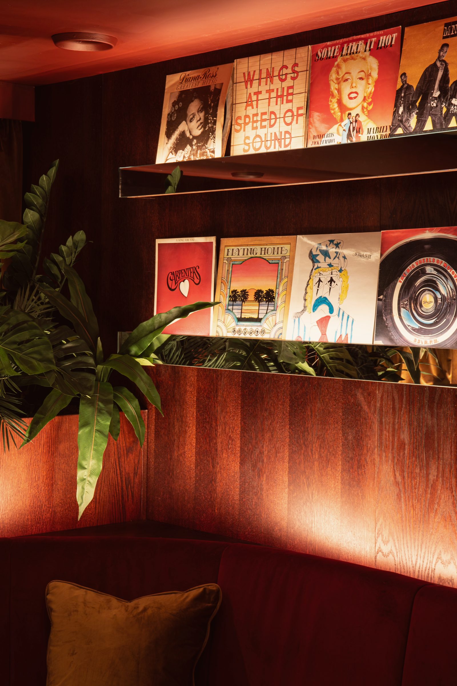 The Vinyl Room: record sleeves on mirrored shelves above walnut panelling